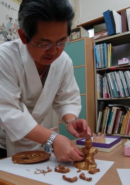 4. Mukoyoshi assembling his Aizen Myo-o statue, decorated with kirikane (gold foil) by his wife.