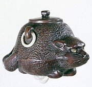 Wood Netsuke. Tanuki as teakettle. Signed Sosui.