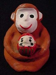 Monkey holding Daruma Doll